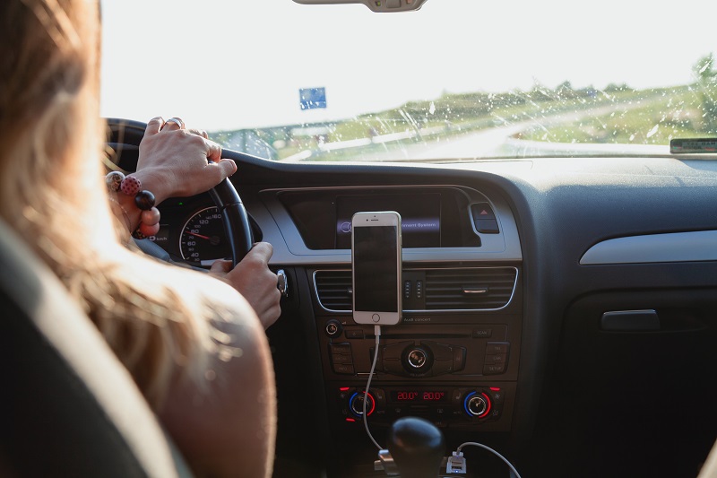 Distracted Driving View of a Woman from the backseat of a Car as She Drives