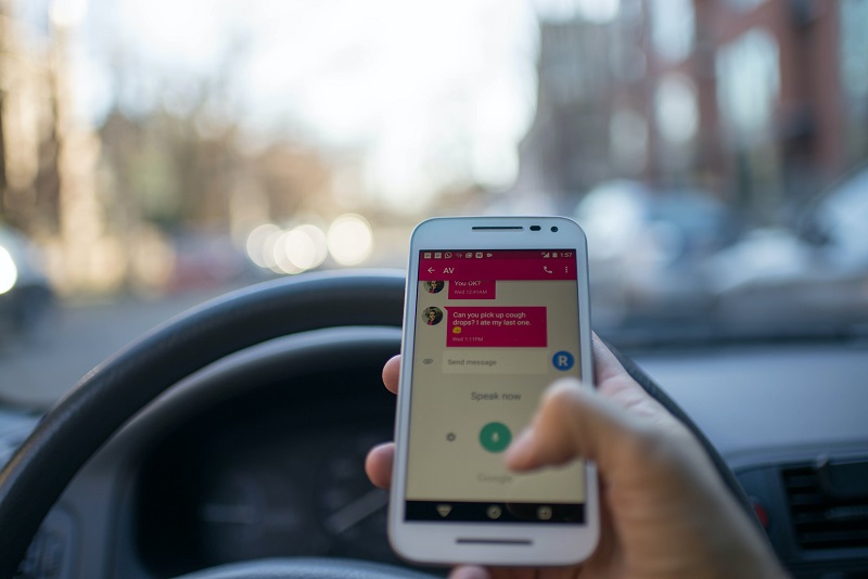 Distracted Driving Close Up of a Person Holding a Phone While They're Driving