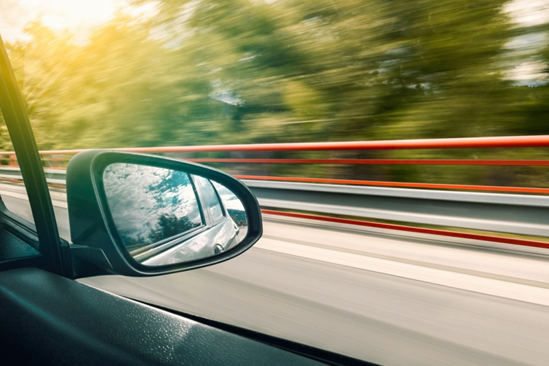 Printable Teen Driving Log Close Up of a Side View Mirror on a Car Driving Down a Road
