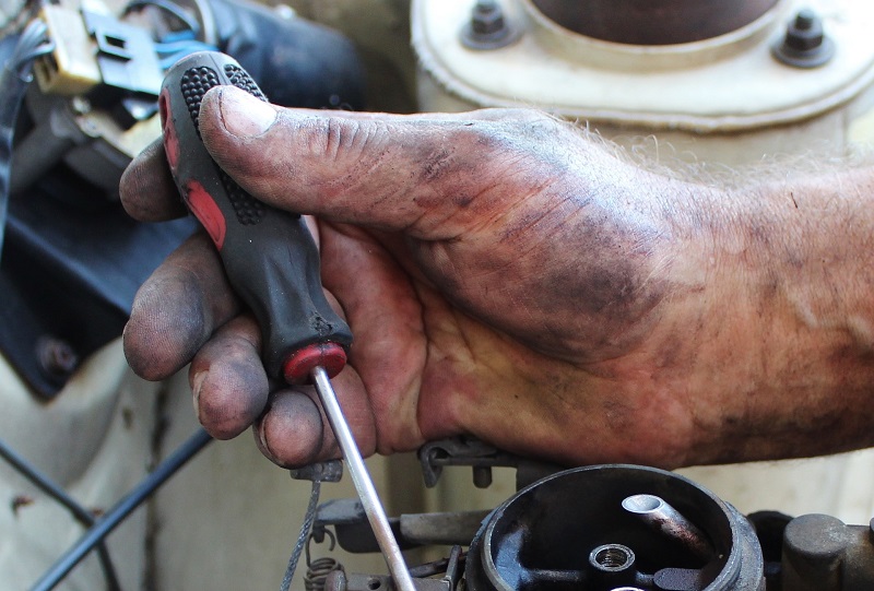 What is a Car Tune Up Dirty Hand Working on a Car
