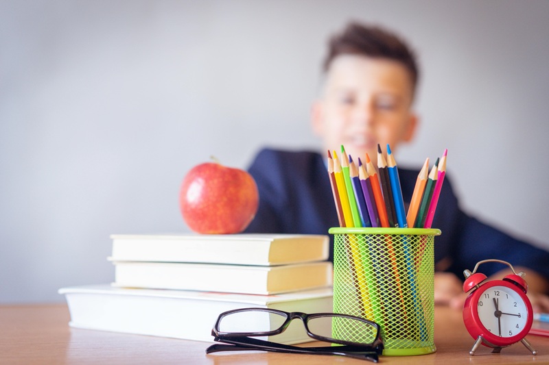 Newport Harbor High School Ranking Information a Stack of Books with an Apple on Top Next to a Small Cup of Pencils and a Pair of Glasses on a Wooden Desk in Front of a Young Teen