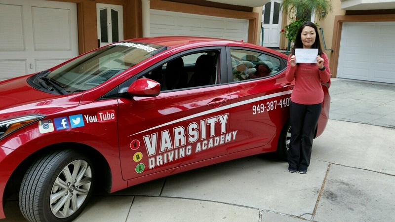 Irvine Adult Driving School Female Student Standing Next to a Training Vehicle