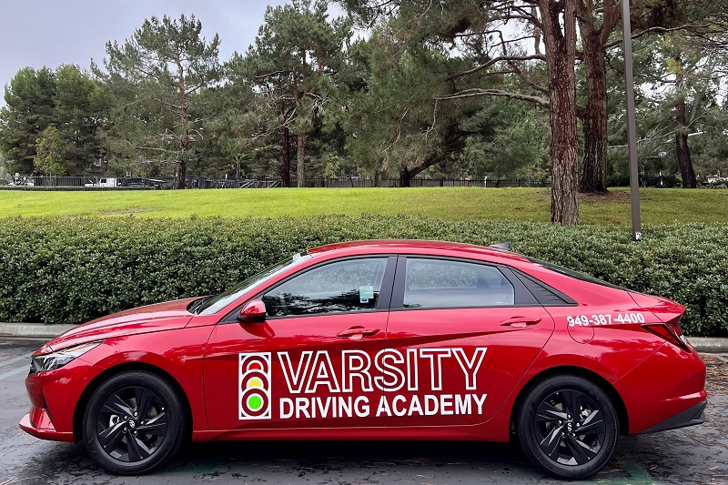 Varsity Driving Academy Best Driving School in Orange County Close Up of a Varsity Driving Academy Training Vehicle Parked in a Parking Lot Next to a Field