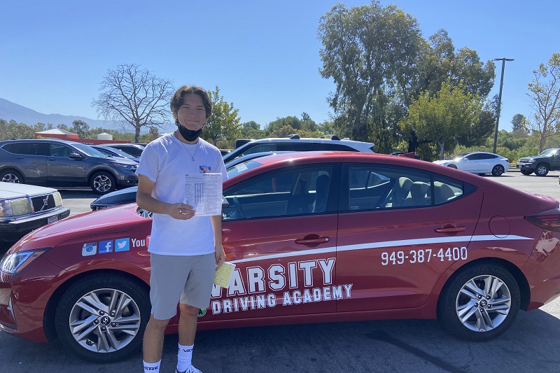 Granite Mountain Charter School Driving School Student Standing Next to a Training Vehicle After Passing the Driving Test