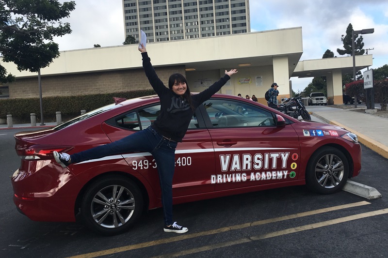 Which Driving School for Woodbridge High School Irvine a Student Celebrating Success Next to a Training Vehicle