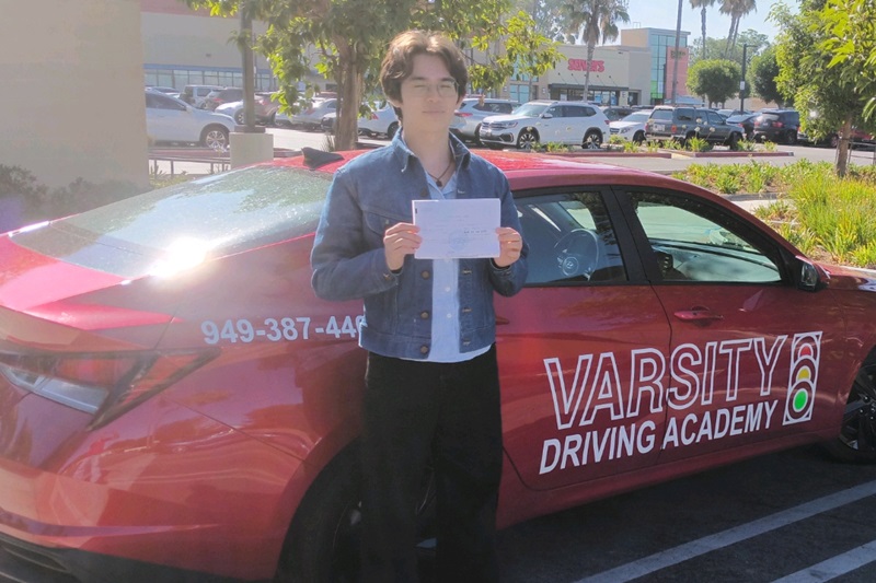Top Rated Tustin Driving School Student Standing Next to a Training Vehicle Parked in a Parking Lot