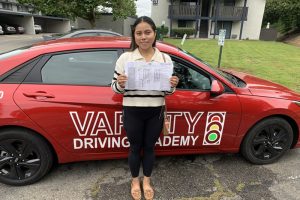 Best Driving School Near Me Irvine Student Standing Next to a Training Vehicle in a DMV Parking Lot