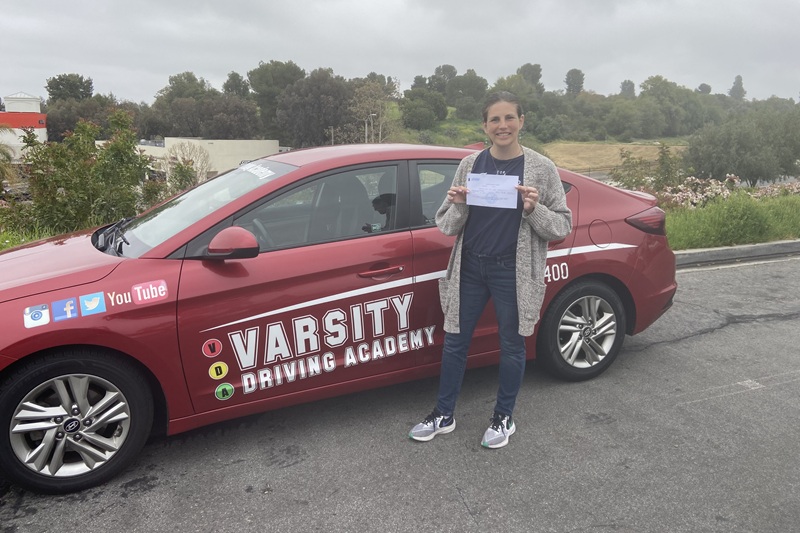 Best Adult Driving School in Irvine a Student Standing Next to a Training Vehicle On a Foggy Day