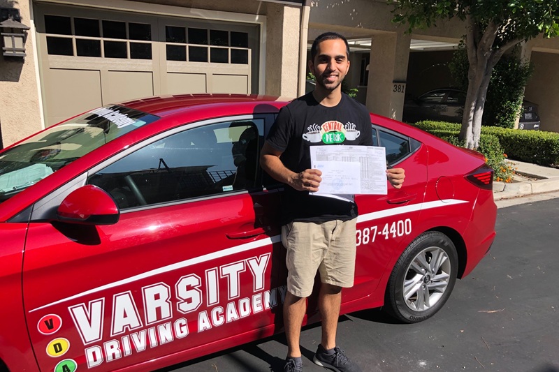Best Driving School Near Me Tustin California Student Standing Next to a Training Vehicle in Front of a Home